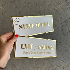 two white and gold business cards being held up