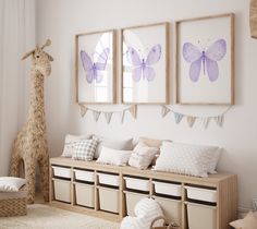 a white room with pink butterfly paintings on the wall and storage bins underneath it