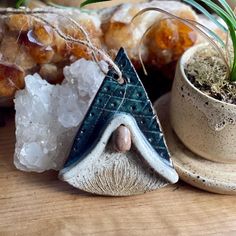 a small potted plant sitting next to a ceramic ornament on top of a wooden table