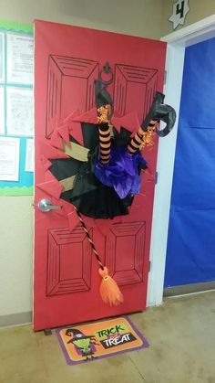 a door decorated for halloween with decorations on the front and side, including a witch's broom