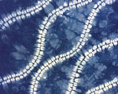 a blue and white tie - dyed fabric with spirals in the middle, as if it were an abstract painting