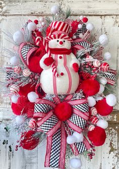 a snowman wreath with red and white ornaments