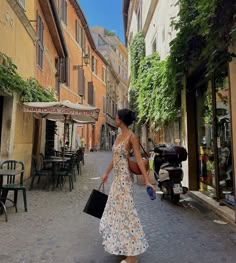 a woman is walking down the street carrying a black purse and shopping bags in her hand