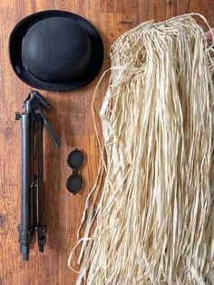 a hat, cane and other items laid out on a wooden table with a black top hat