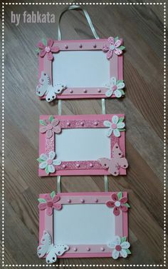 two pink frames with flowers and butterflies are hanging on the floor next to each other