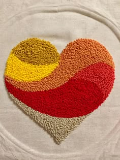 a heart - shaped dishcloth with multicolored circles on it