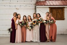 a group of women standing next to each other in front of a white building with string lights