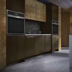 an empty kitchen with brown cabinets and black appliances