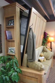 a living room with a couch and bookshelf that is open to reveal a coat rack