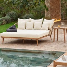 a couch and table sitting next to a pool