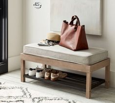 a brown purse sitting on top of a wooden bench next to a white rug and black door