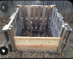 a wooden box filled with lots of wood and wire fenced in to the yard