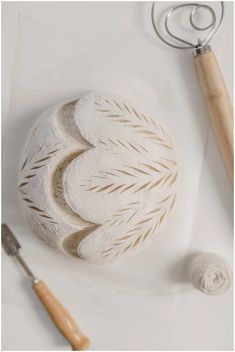 a white object sitting on top of a table next to a crochet hook