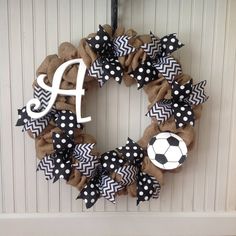 a wreath with a soccer ball and monogrammed letters hanging on the front door