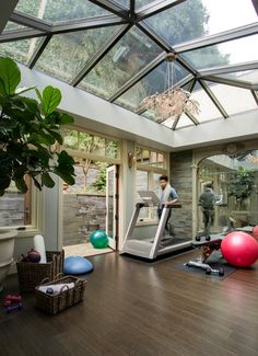 a man is running on a treadmill in a gym with exercise balls and other equipment