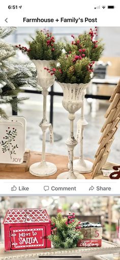 two white vases filled with flowers on top of a table next to other items