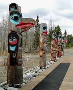 several totems lined up on the side of a road