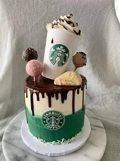 a starbucks cake is decorated with cookies, marshmallows, and other treats