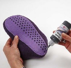 someone is painting the inside of a purple shoe with black dots on it and an acrylic glue