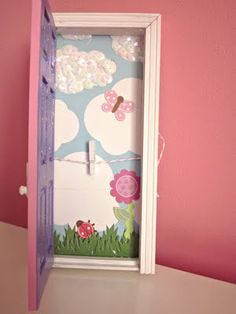 an open door to a pink room with flowers and butterflies painted on the wall behind it