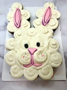 a cupcake shaped like a bunny on top of a white plate with icing