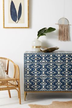 a blue and white dresser sitting next to a chair