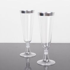 two clear glass vases sitting on top of a table