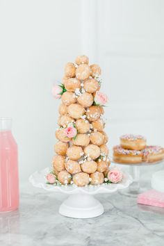 a tower of donuts sitting on top of a table next to doughnuts