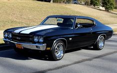 a black and white muscle car parked on the street