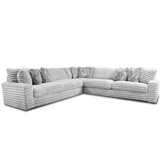 a large sectional couch with pillows on it's back and side facing the camera