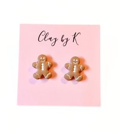 a pair of ginger earrings on a pink card with the word clay by k written in black