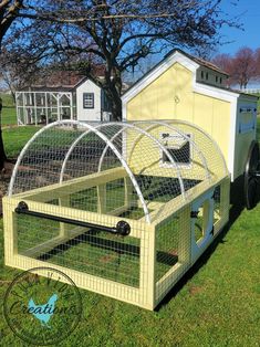 a yellow chicken coop sitting in the grass