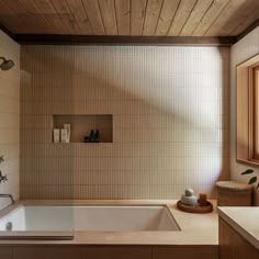 a bath tub sitting under a window next to a sink