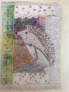 a piece of art that looks like a hedgehog on a patchwork cloth background