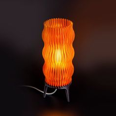 an orange lamp is lit up on a black surface with the light turned on and dimming