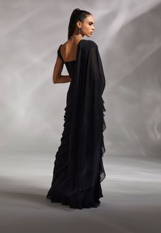 Editor's Note A pre-draped sari worn over a corset is the latest trend everyone seems keen to jump on. Take the leap with this classic black number. Color: Black Fabric: Satin, tulle and georgette Fit type: Corset: fitted Neckline: Sweetheart Components: Sari, corset Occasion: Cocktail and Wedding Guest Care: Dry Clean Only About the Designer The crux and essence of the label, Divya Aggarwal, is to challenge and revamp the face of ordinary traditional wear while being customer oriented. Driven b Corset Sari Blouses, Designer Black Saree, Black Corset Blouse, Drape Saree Designer 2023, Sweetheart Neckline Blouse Pattern, Corset Saree Blouse Design, Corset Outfit Indian, Saree With Corset Blouse, Pre Draped Saree Gown