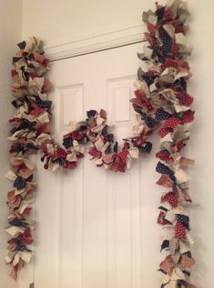 the letter h made out of old american flags is displayed on a door frame in front of a white door