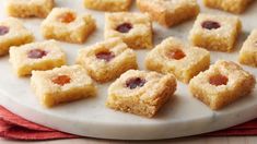 small pieces of cake on a white plate with red cloth and napkin next to it