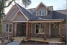 a house that is made out of wood and has stone on the front porch, and covered in shingles