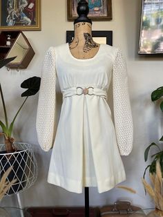 "Absolutely stunning, one of a kind 1960s vintage mod mini dress! Color can best be described as an off-white or cream. Scoop neckline. A-line to flatter your figure. Gorgeous bishop long sleeves made with a crochet/lace-like fabric. Original faux belt intact with a silver buckle closure (see picture). Front center pleat on the skirt. Insanely adorable. Perfect for a formal event or even as a wedding dress for your picture perfect vintage inspired wedding! In excellent vintage condition! Measure White Vintage Mini Dress, 60s Folk Fashion, Short White Vintage Dress, Cream A-line Mini Dress For Fall, Off White Long Sleeve Mini Dress, Vintage Fitted Long Sleeve Mini Dress, Fitted Cream Vintage Mini Dress, Mod Long Sleeve Mini Dress For Spring, Vintage Cream Mini Dress