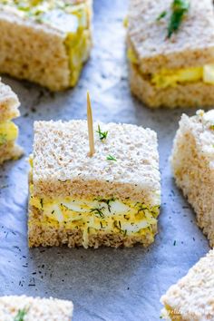 an egg salad sandwich cut into squares with a toothpick sticking in the middle