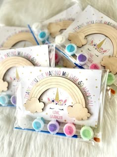 four wooden magnets with unicorn designs on them and some colored markers in front of them