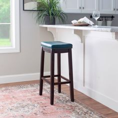 a bar stool sitting in front of a counter with a potted plant on it