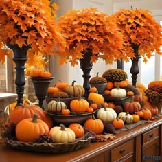 an arrangement of pumpkins and gourds on a table in front of trees