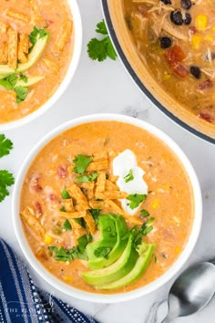 three bowls of chicken tortilla soup with avocado, sour cream and cilantro