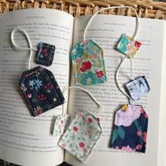 an open book with some small pieces of fabric hanging from it's cover and string