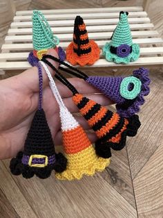 small crocheted halloween decorations are being held in someone's hand