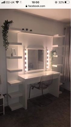 a white desk with lights on it next to a mirror and shelf filled with books