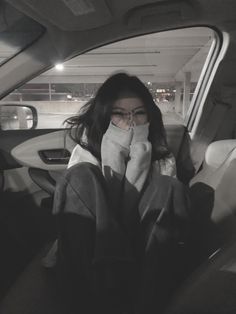 a woman sitting in the back seat of a car with her hand on her face