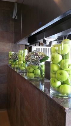 there are many vases filled with green apples